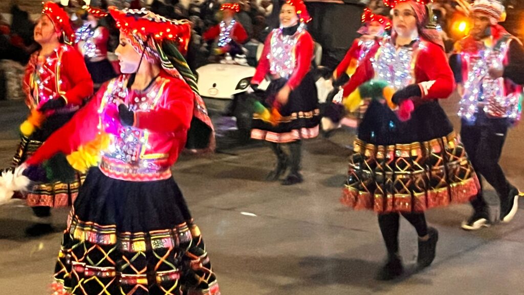 Event participants promoting the country of Peru pass through downtown Denver as part of the annual Parade of Lights on Saturday, Dec. 3, 2022.