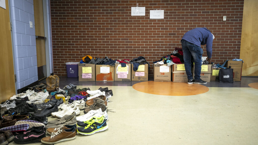 Piles of donated items available for people arriving from the U.S. southern border inside a rec center serving as Denver's second emergency shelter. Jan. 6, 2023.