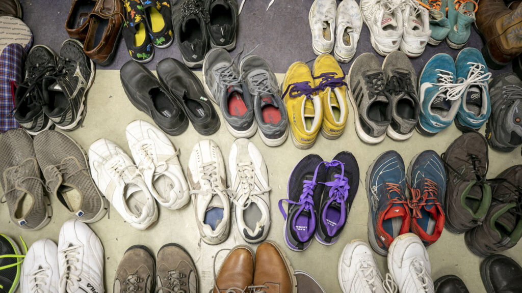 Donated shoes available for people arriving from the U.S. southern border inside a rec center serving as Denver's second emergency shelter. Jan. 6, 2023.