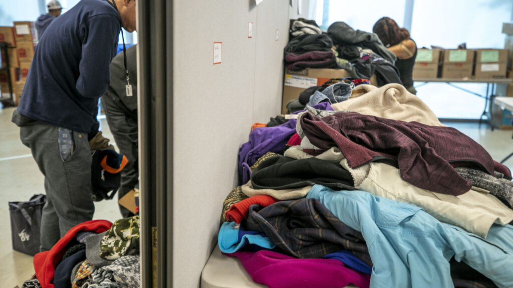 Piles of donated items available for people arriving from the U.S. southern border inside a rec center serving as Denver's second emergency shelter. Jan. 6, 2023.