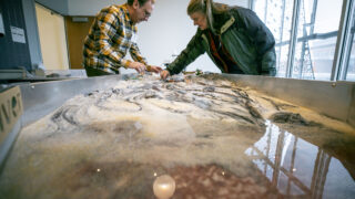 Andrew Warnock (left) and Carol Dollard simulate water systems in an educational area of Colorado State University's new Hydro building on their Spur Campus, part of the National Western Center. Jan. 6, 2023.