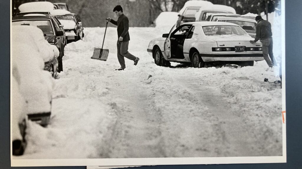 Brian Goodwin, left, and Chuck Allaire, right, try to get their friends car out of the snow at Marion Street and 12th Avenue after a December 1987 blizzard.