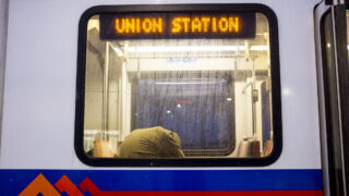 Ricci Autry is hunched over on the W Line RTD train he's been riding since routes began before dawn on Feb. 22, 2023.