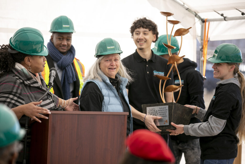 Donna Garnett, executive director of the Montbello Organizing Committee, tearfully accepts an award from her colleagues during a groundbreaking for the FreshLo grocery and community project in Montbello. March 2, 2023.  Kevin J. Beaty/Denverite