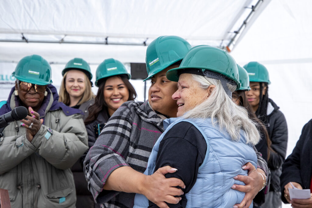 LaToya Petty embraces Donna Garnett, executive director of the Montbello Organizing Committee, as she tearfully accepts an award from her colleagues during a groundbreaking for the FreshLo project in Montbello. March 2, 2023.  Kevin J. Beaty/Denverite