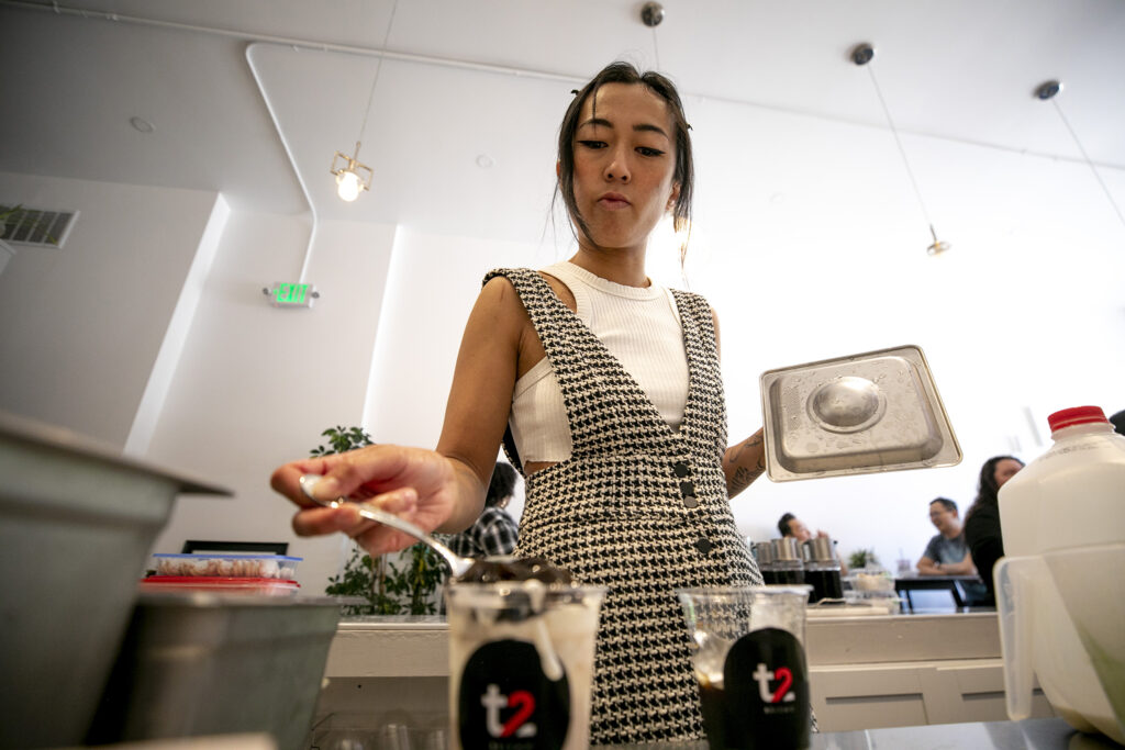 Shasitie Nguyen makes a drink behind the bar at Ti Cafe on South Broadway. June 24, 2023.