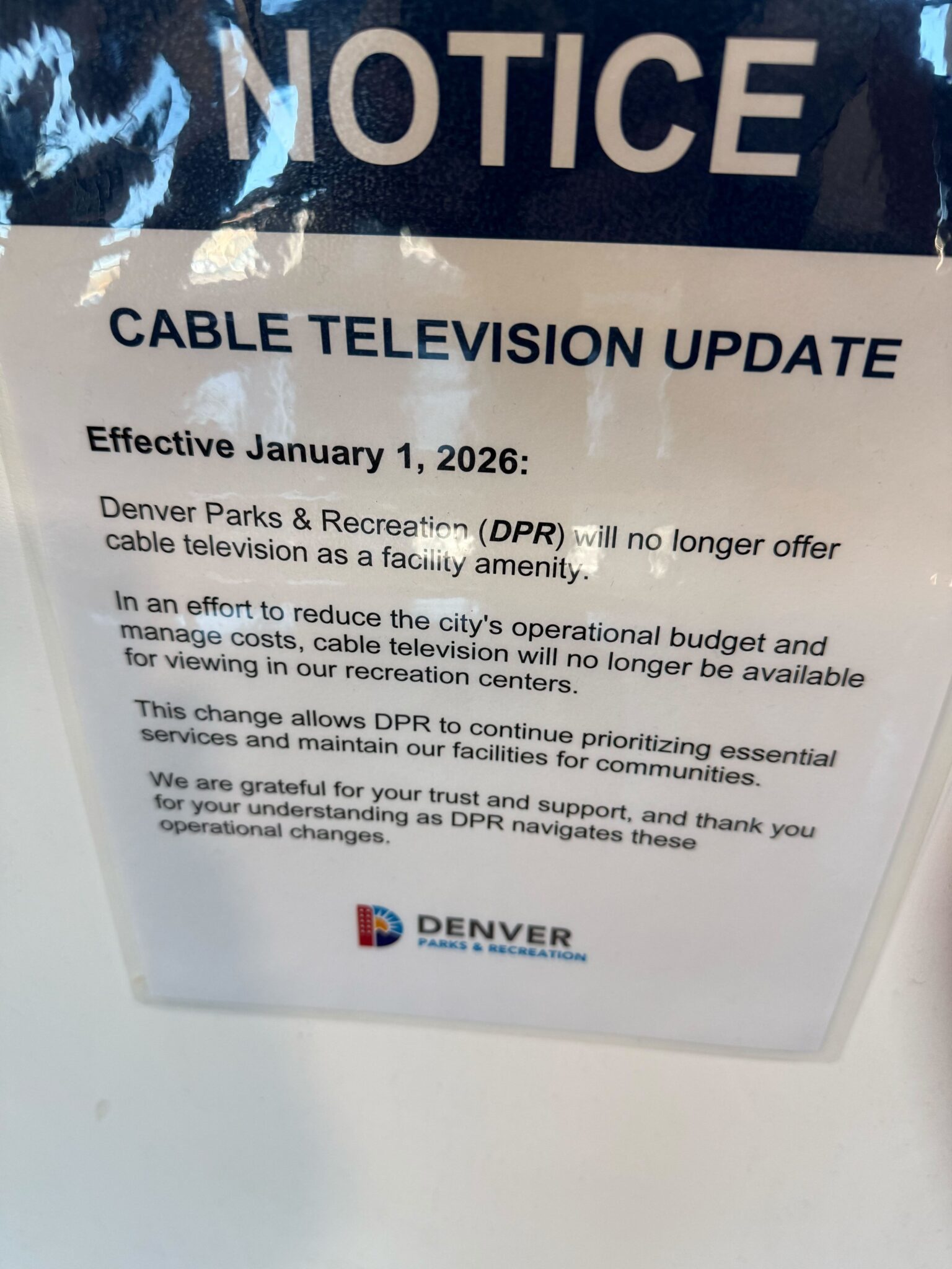 A laminated piece of paper is posted to a white wall. The paper is titled "Notice: Cable  Television Update" and describes the city's decision to cut cable at rec centers as of Jan. 1, 2026.